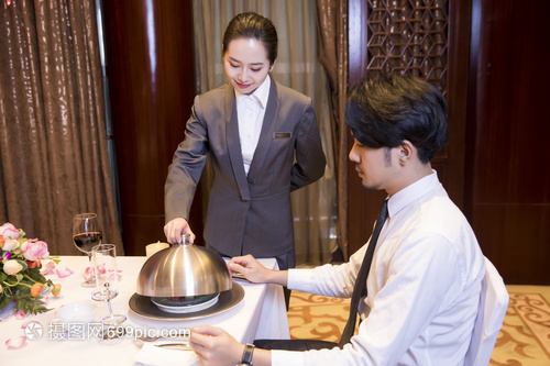 酒店服務員給顧客打開餐蓋